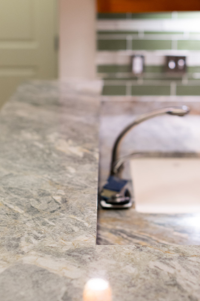 Example of a transitional home design design with an undermount sink, granite countertops, green backsplash, stone slab backsplash and stainless steel appliances