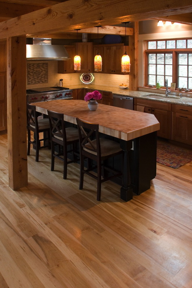 Mountain style light wood floor kitchen photo in Boston with an undermount sink, raised-panel cabinets, medium tone wood cabinets, stainless steel appliances and an island
