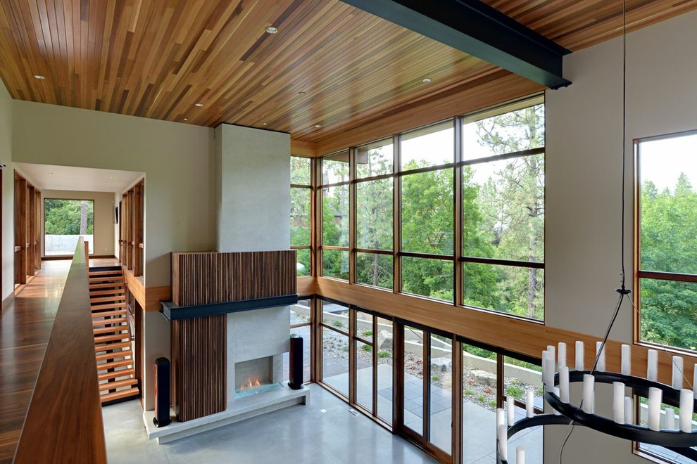 Living room - large modern open concept concrete floor living room idea in Seattle with a standard fireplace and a concrete fireplace