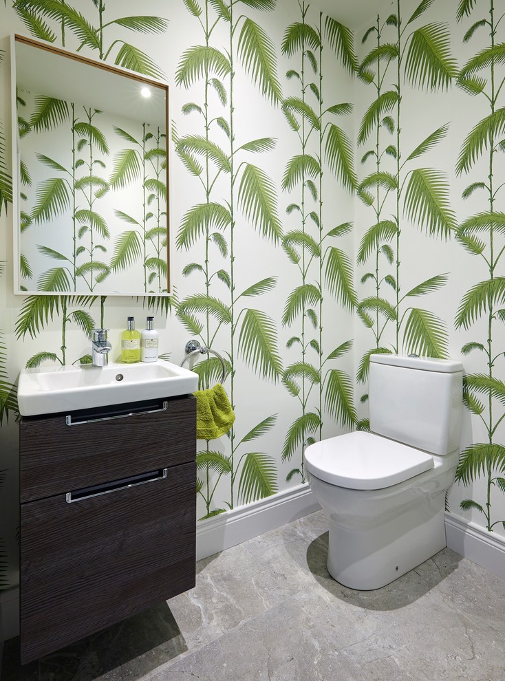 Photo of a mid-sized tropical powder room in Dublin with a one-piece toilet, multi-coloured walls and a wall-mount sink.