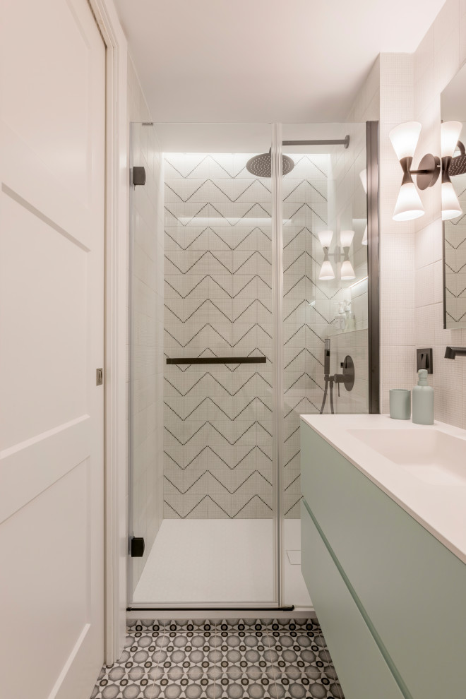 Exempel på ett litet modernt vit vitt badrum med dusch, med släta luckor, gröna skåp, en kantlös dusch, en vägghängd toalettstol, vit kakel, keramikplattor, vita väggar, klinkergolv i keramik, ett nedsänkt handfat, grått golv och dusch med gångjärnsdörr