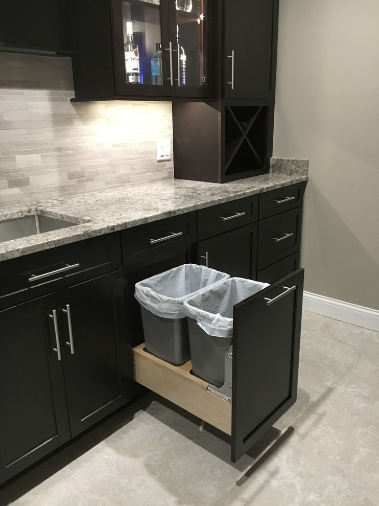 Large modern single-wall seated home bar in Other with an undermount sink, shaker cabinets, dark wood cabinets, granite benchtops, grey splashback, mosaic tile splashback, porcelain floors and grey floor.