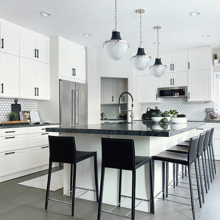 Example of a large transitional l-shaped kitchen pantry design in Calgary with shaker cabinets, an island and gray countertops