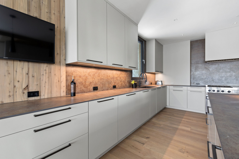 Große Moderne Wohnküche in L-Form mit flächenbündigen Schrankfronten, weißen Schränken, Küchenrückwand in Grau, Kücheninsel und grauer Arbeitsplatte in New York