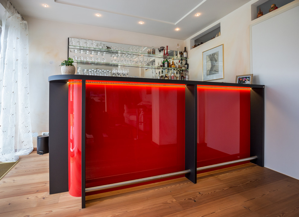 Photo of a contemporary home bar in Cologne with solid surface benchtops.