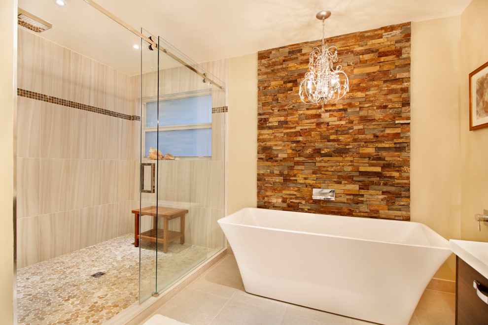 This is an example of a large transitional master bathroom in Miami with flat-panel cabinets, medium wood cabinets, a freestanding tub, an alcove shower, stone tile, a vessel sink, engineered quartz benchtops, a sliding shower screen, white benchtops, a double vanity, a built-in vanity, beige walls, beige floor, a one-piece toilet, beige tile and limestone floors.