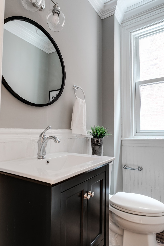 Inspiration for a mid-sized transitional powder room in Richmond with shaker cabinets, black cabinets, a two-piece toilet, grey walls, an undermount sink, white benchtops and a built-in vanity.