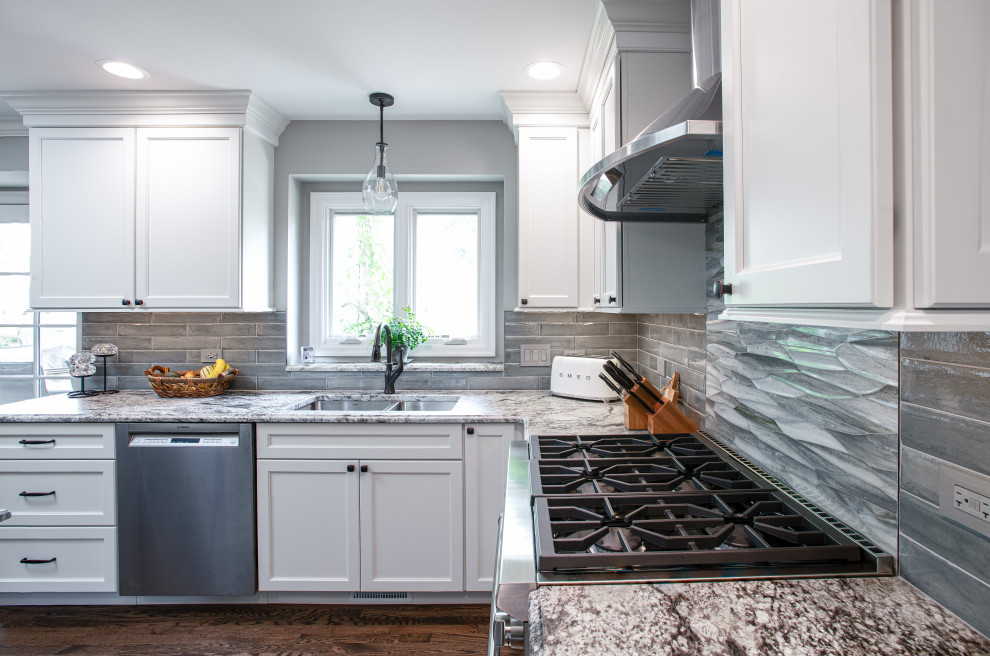 Inspiration for a mid-sized transitional u-shaped dark wood floor and brown floor open concept kitchen remodel in Chicago with a double-bowl sink, shaker cabinets, white cabinets, quartz countertops, blue backsplash, porcelain backsplash, stainless steel appliances, an island and gray countertops