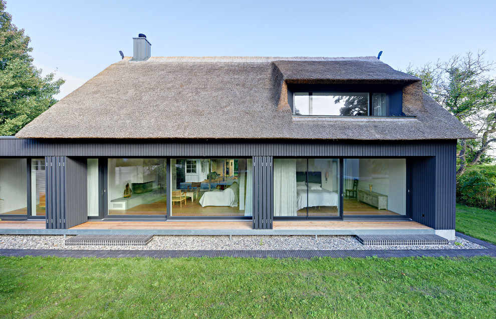 Inspiration for a mid-sized contemporary two-storey black exterior in Berlin with wood siding and a gable roof.