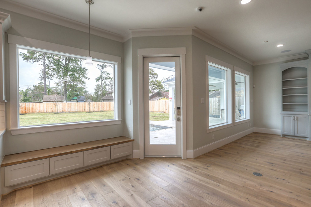 Inspiration for a mid-sized transitional u-shaped light wood floor and beige floor enclosed kitchen remodel in Orlando with shaker cabinets, an island, a double-bowl sink, gray cabinets, quartz countertops, white backsplash, subway tile backsplash and stainless steel appliances