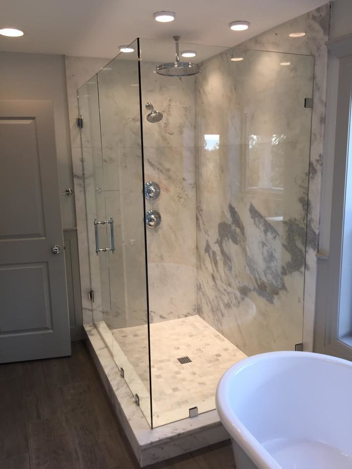 Photo of a mid-sized transitional master bathroom in Portland with an undermount sink, recessed-panel cabinets, grey cabinets, marble benchtops, a freestanding tub, a corner shower, a one-piece toilet, gray tile, grey walls and porcelain floors.