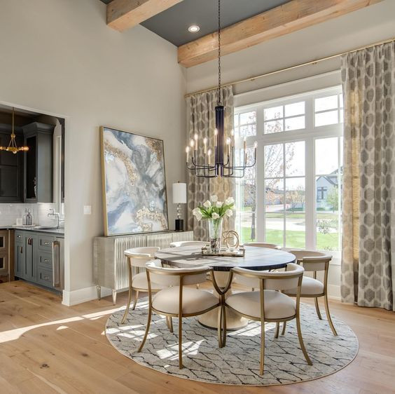 Immagine di una sala da pranzo aperta verso il soggiorno chic con pareti beige e pavimento in legno verniciato