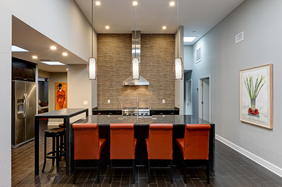 Inspiration for a large transitional u-shaped cement tile floor and brown floor open concept kitchen remodel in Jacksonville with a drop-in sink, flat-panel cabinets, black cabinets, granite countertops, multicolored backsplash, stone tile backsplash, stainless steel appliances and an island