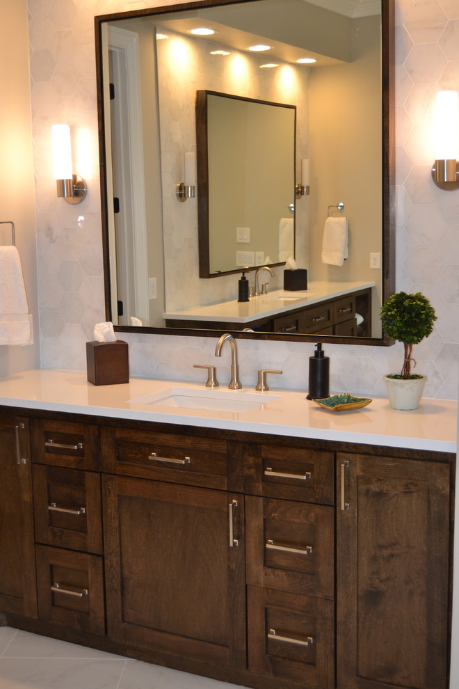 This is an example of a large transitional master bathroom in Dallas with shaker cabinets, medium wood cabinets, a freestanding tub, a corner shower, a two-piece toilet, white tile, marble, grey walls, porcelain floors, an undermount sink, quartzite benchtops, white floor and a hinged shower door.