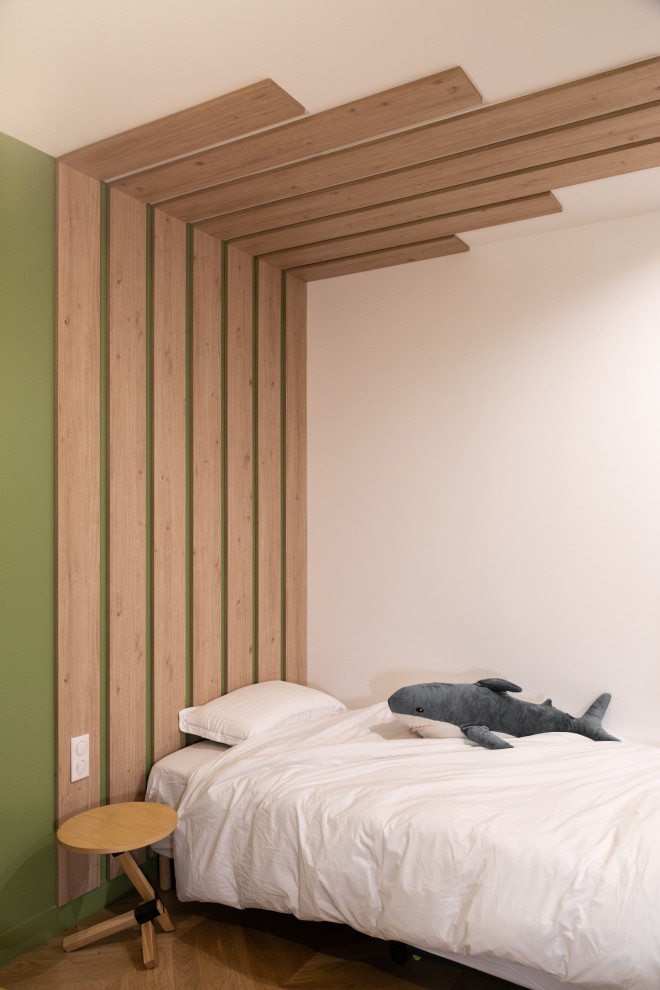 Aménagement d'une grande chambre neutre de 4 à 10 ans contemporaine avec un bureau, un mur vert, un sol en bois brun et un sol marron.