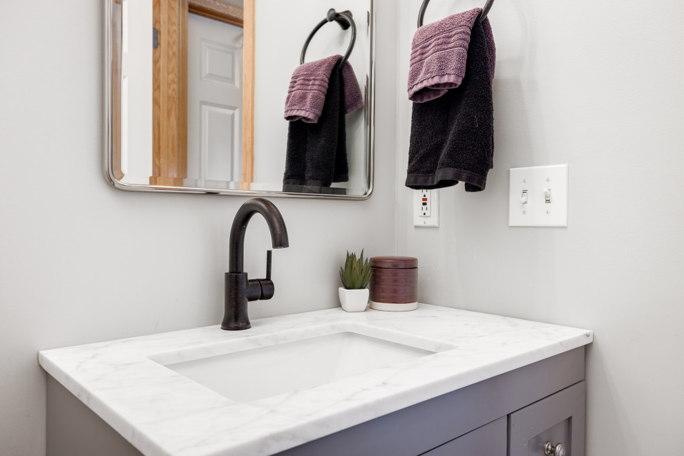 Small 3/4 vinyl floor, white floor and single-sink bathroom photo in Minneapolis with shaker cabinets, gray cabinets, a two-piece toilet, gray walls, an undermount sink, quartz countertops, white countertops and a freestanding vanity