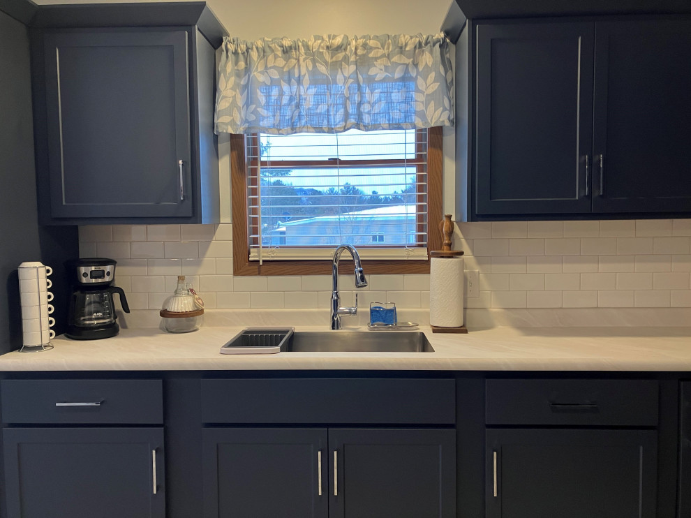Bild på ett mellanstort funkis kök, med skåp i shakerstil, blå skåp, laminatbänkskiva, vitt stänkskydd och stänkskydd i tunnelbanekakel