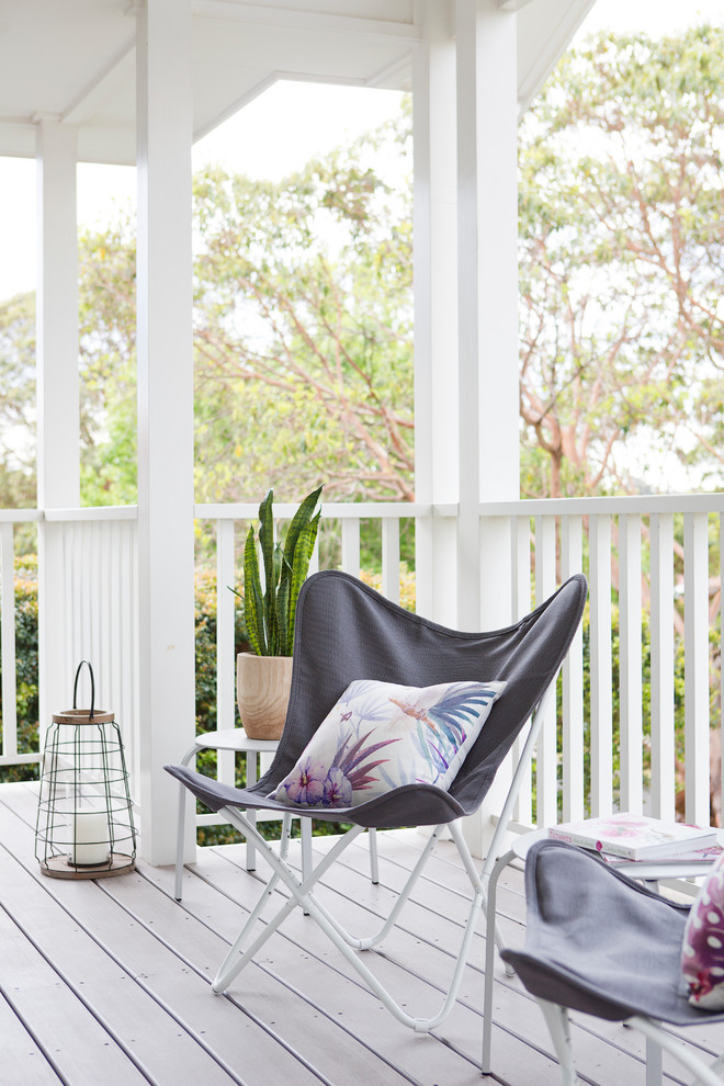 Inspiration for a large beach style balcony in Sydney with a roof extension and wood railing.