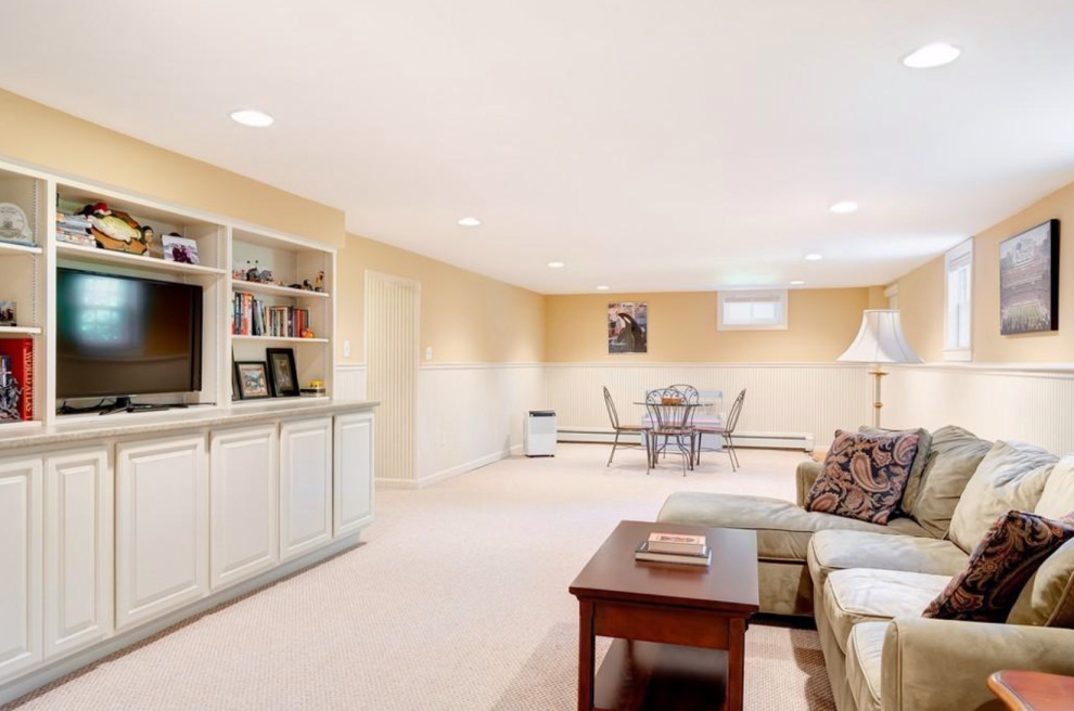 Large traditional look-out basement in Boston with beige walls, carpet and beige floor.