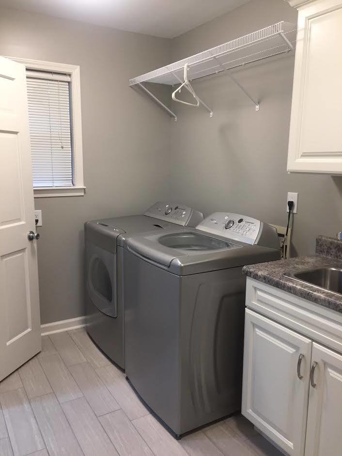 Photo of a mid-sized traditional dedicated laundry room in Other with an undermount sink, raised-panel cabinets, white cabinets, laminate benchtops and a side-by-side washer and dryer.