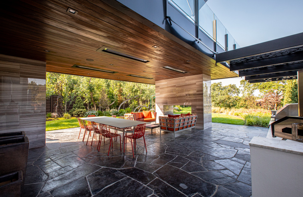 Идея дизайна: огромный двор на заднем дворе в стиле ретро с летней кухней, покрытием из каменной брусчатки и навесом