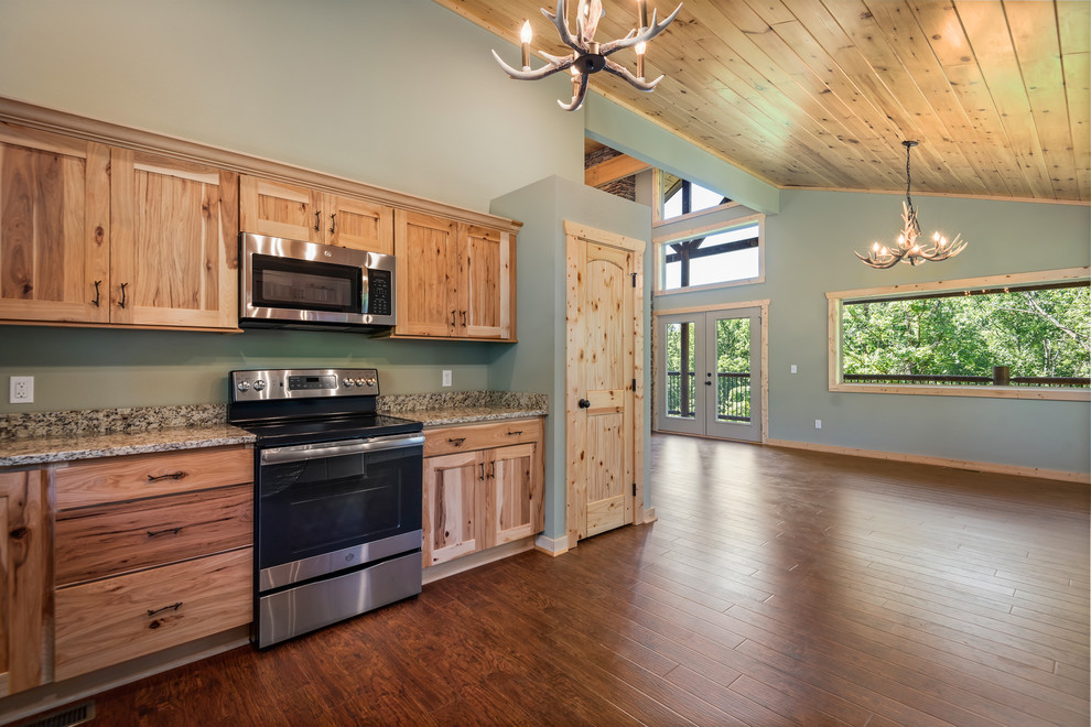 Inspiration for a large rustic u-shaped laminate floor and brown floor eat-in kitchen remodel with a double-bowl sink, recessed-panel cabinets, light wood cabinets, granite countertops, multicolored backsplash, stainless steel appliances, no island and multicolored countertops