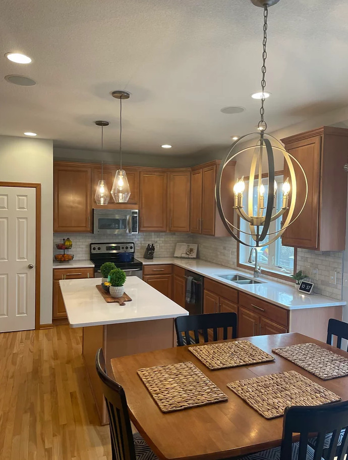 Exempel på ett mellanstort klassiskt brun brunt kök, med en dubbel diskho, skåp i shakerstil, skåp i mellenmörkt trä, bänkskiva i kvarts, grått stänkskydd, stänkskydd i marmor, rostfria vitvaror, ljust trägolv, en köksö och brunt golv