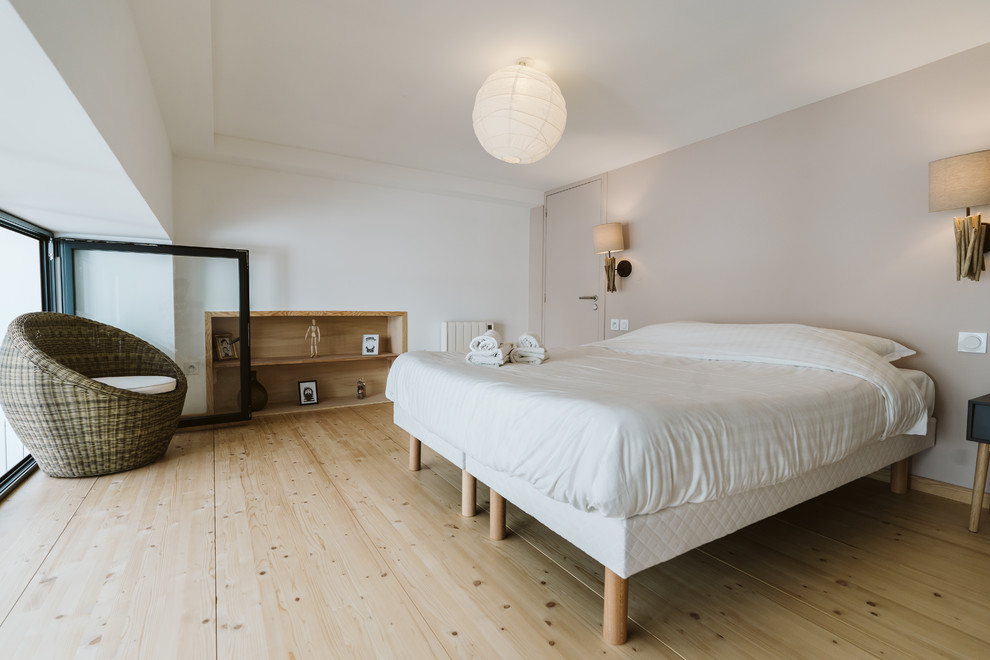 Small contemporary master bedroom in Lille with white walls, light hardwood floors, no fireplace and brown floor.