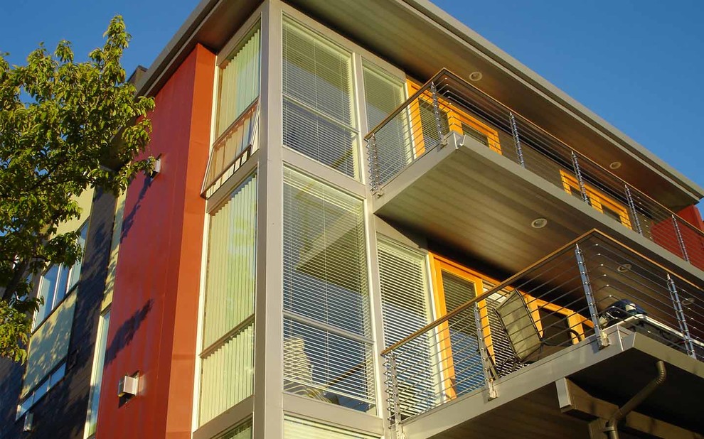 Photo of a mid-sized modern two-storey red exterior in Seattle with metal siding.