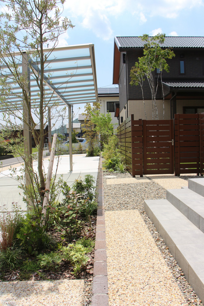 This is an example of a mid-sized modern front yard full sun garden for spring in Other with with privacy feature, concrete pavers and a vinyl fence.