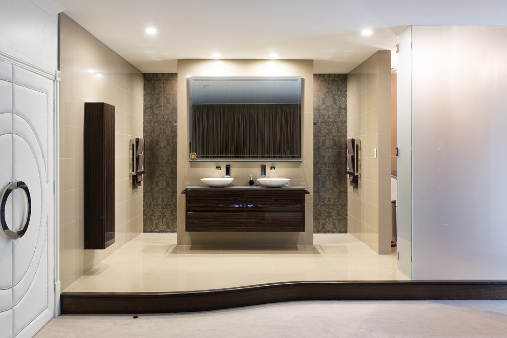 This is an example of a large contemporary bathroom in Melbourne with flat-panel cabinets, dark wood cabinets, ceramic tile, beige walls, porcelain floors, a vessel sink and marble benchtops.