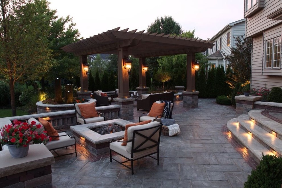 Photo of a traditional backyard patio in Chicago with a fire feature and brick pavers.