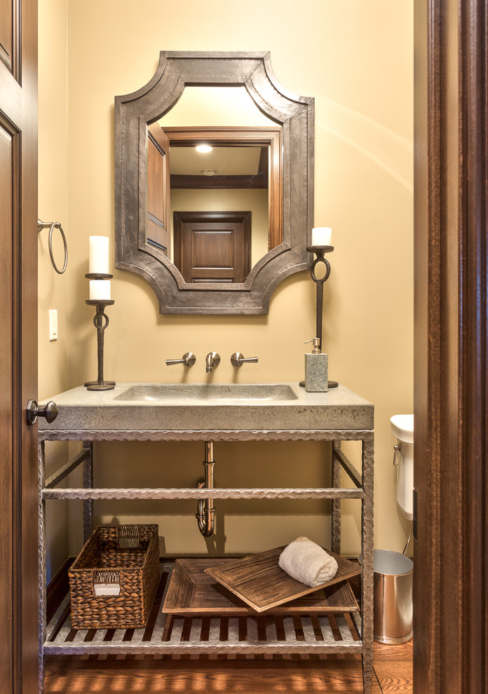 This is an example of a small country 3/4 bathroom in Other with concrete benchtops, yellow walls, medium hardwood floors, an integrated sink, grey cabinets, brown floor, grey benchtops, a single vanity and a freestanding vanity.