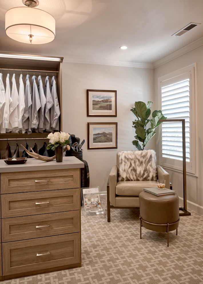 Photo of a mid-sized transitional men's walk-in wardrobe in San Francisco with raised-panel cabinets, light wood cabinets and carpet.