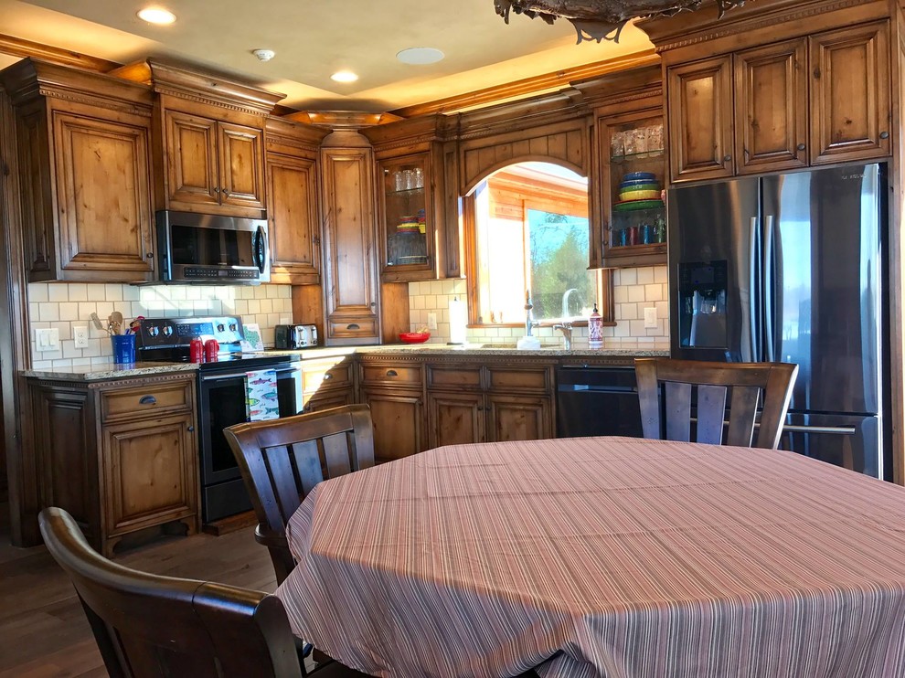 This is an example of a medium sized classic l-shaped kitchen/diner in Dallas with a submerged sink, raised-panel cabinets, beige cabinets, granite worktops, white splashback, ceramic splashback, stainless steel appliances, dark hardwood flooring, brown floors and beige worktops.
