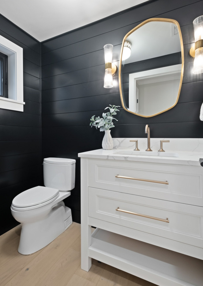 Small cottage light wood floor, beige floor and wood wall powder room photo in Seattle with beaded inset cabinets, white cabinets, a two-piece toilet, black walls, an undermount sink, quartz countertops, white countertops and a freestanding vanity