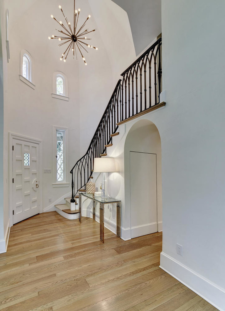 Example of a transitional light wood floor foyer design in Austin with white walls and a white front door