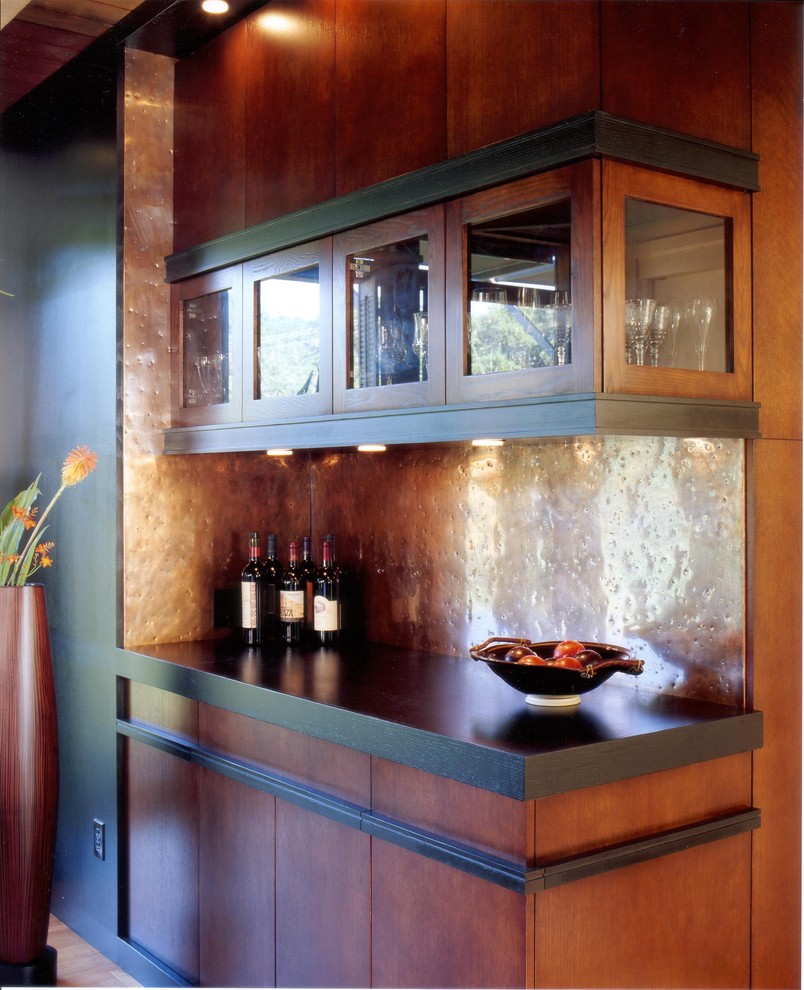 Design ideas for a mid-sized contemporary single-wall home bar in San Francisco with metal splashback, flat-panel cabinets and medium wood cabinets.