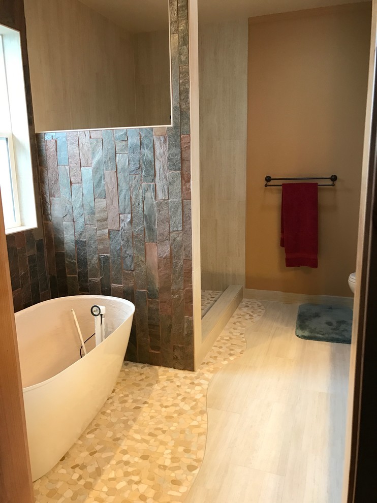 Large mountain style master multicolored tile and slate tile light wood floor and beige floor freestanding bathtub photo with beige walls