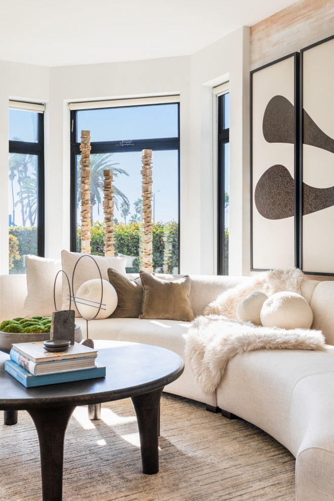 ロサンゼルスにあるお手頃価格の中くらいなコンテンポラリースタイルのおしゃれな独立型リビング (白い壁、コーナー設置型暖炉、漆喰の暖炉まわり、壁掛け型テレビ) の写真