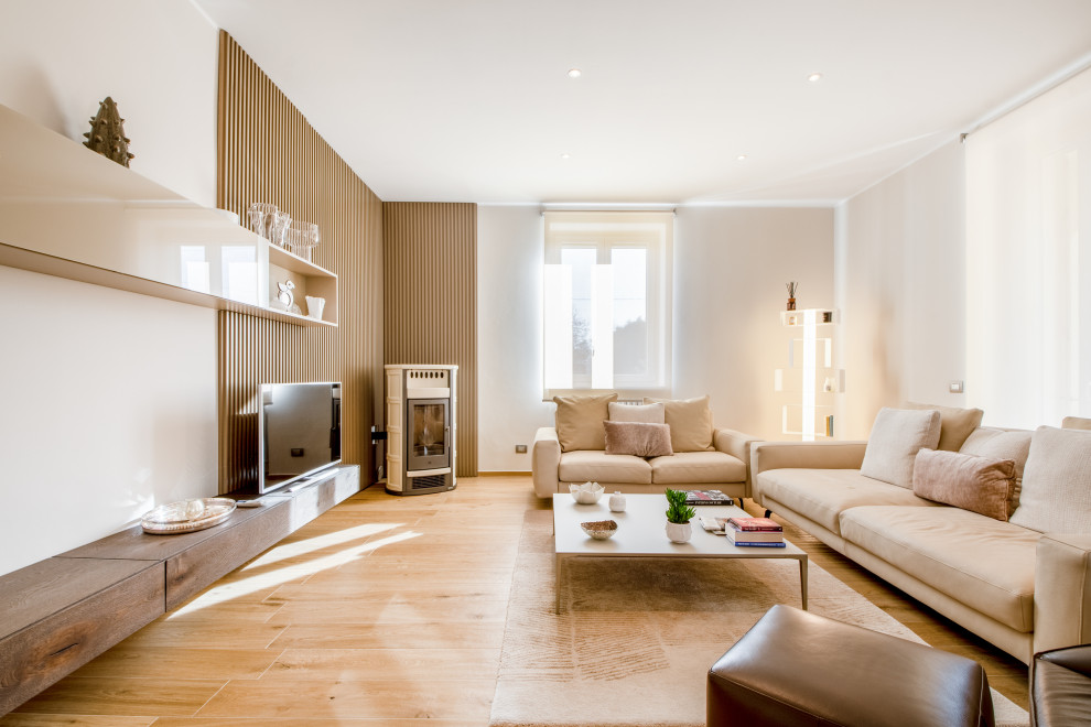 This is an example of a mid-sized contemporary open concept living room in Milan with ceramic floors, a wood stove, a tile fireplace surround, beige floor, recessed and decorative wall panelling.