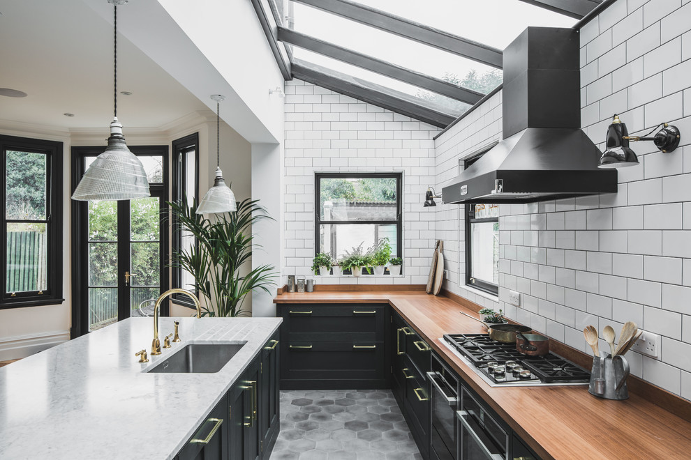 Design ideas for a large industrial galley eat-in kitchen in Other with an undermount sink, shaker cabinets, wood benchtops, white splashback, subway tile splashback, with island, grey floor and cement tiles.