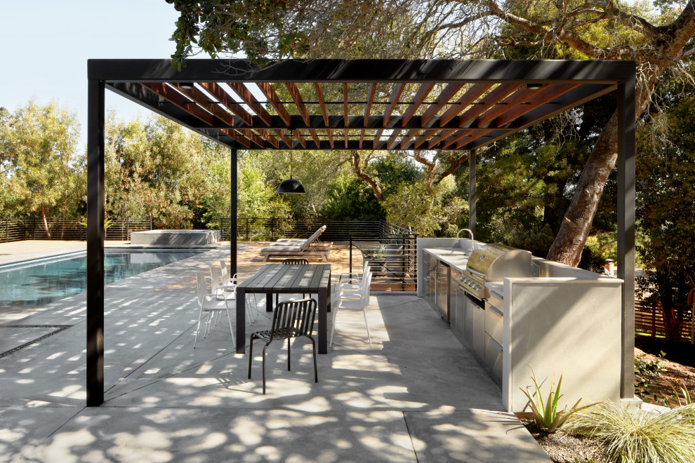 Photo of an expansive midcentury backyard patio in San Francisco with an outdoor kitchen, a pergola and concrete slab.