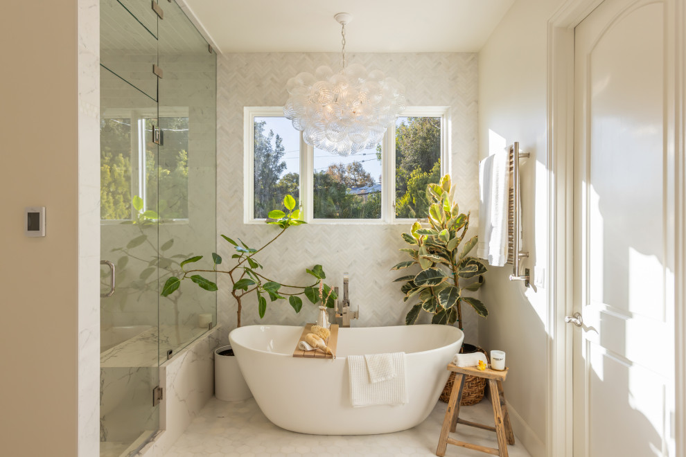 Example of a tuscan master white tile and marble tile freestanding bathtub design in Los Angeles with a hinged shower door