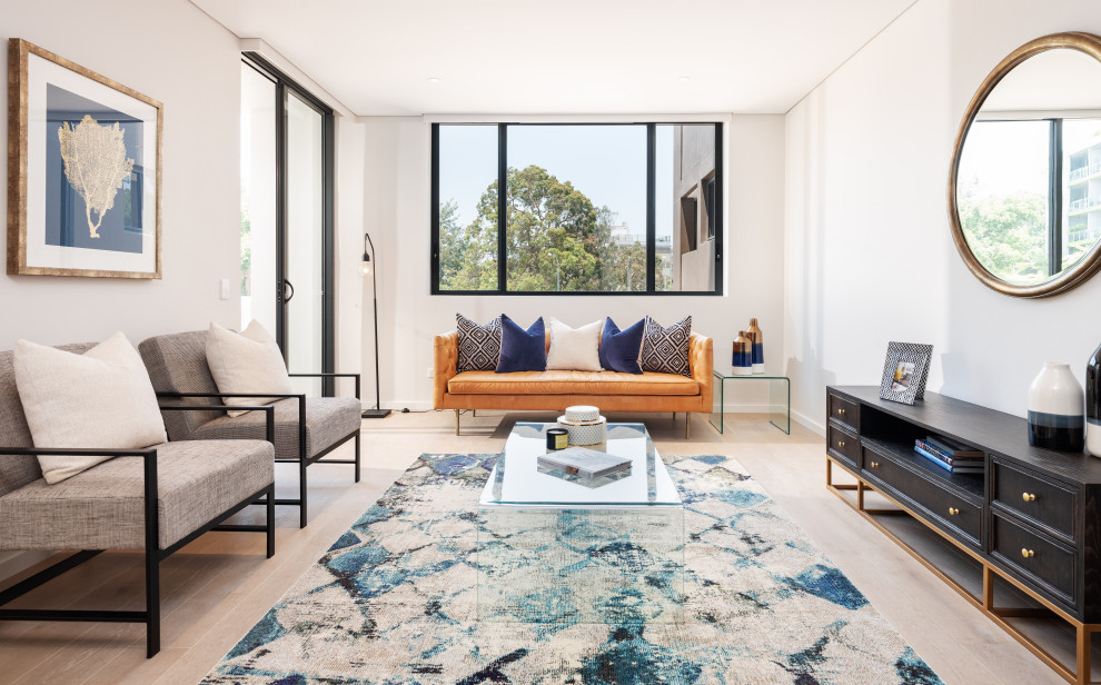 This is an example of a small transitional formal open concept living room in Sydney with white walls, light hardwood floors, a freestanding tv, no fireplace and beige floor.