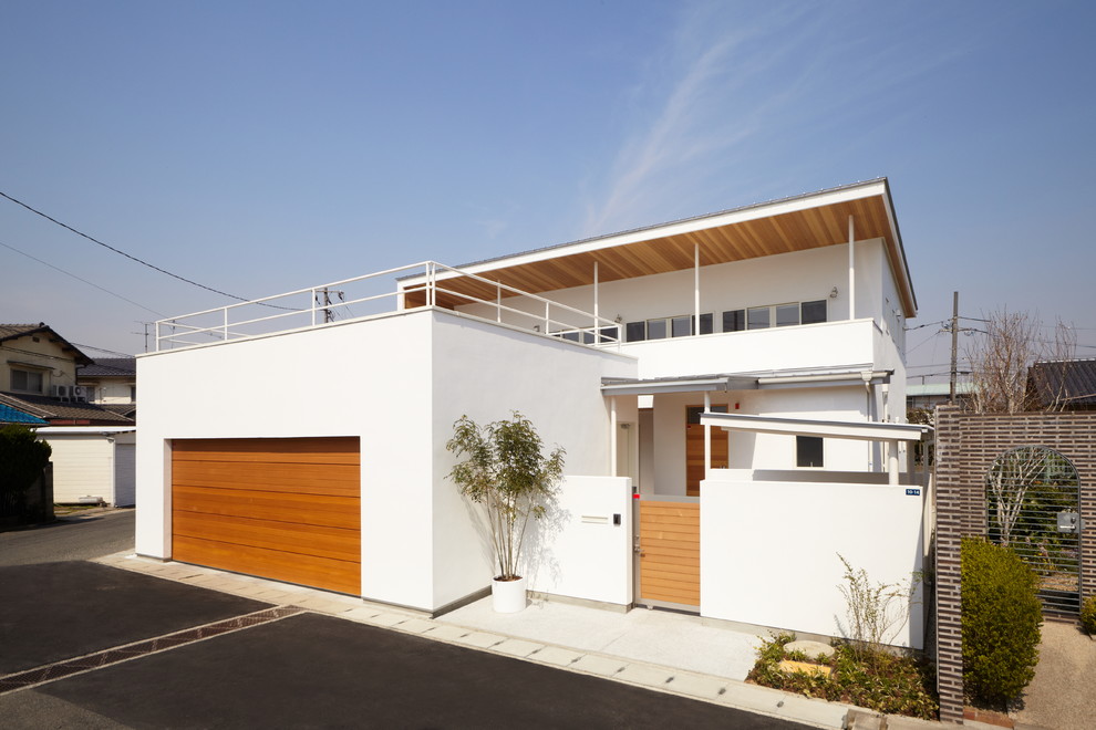Contemporary two-storey white exterior in Other with a flat roof.