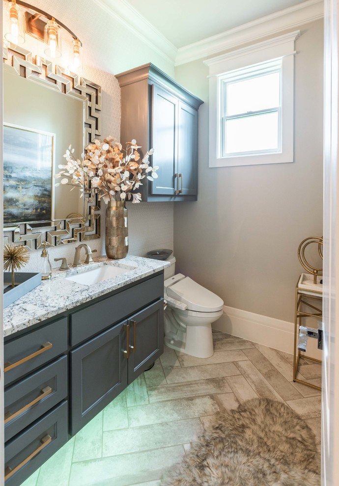Design ideas for a large transitional powder room in Dallas with raised-panel cabinets, grey cabinets, a bidet, white tile, mosaic tile, beige walls, ceramic floors, an undermount sink, granite benchtops, beige floor and grey benchtops.