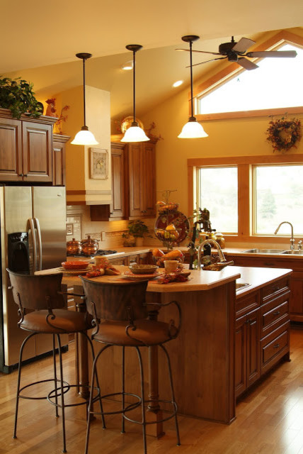 Inspiration for a large rustic u-shaped medium tone wood floor eat-in kitchen remodel with a double-bowl sink, beaded inset cabinets, medium tone wood cabinets, granite countertops, beige backsplash, stainless steel appliances and an island