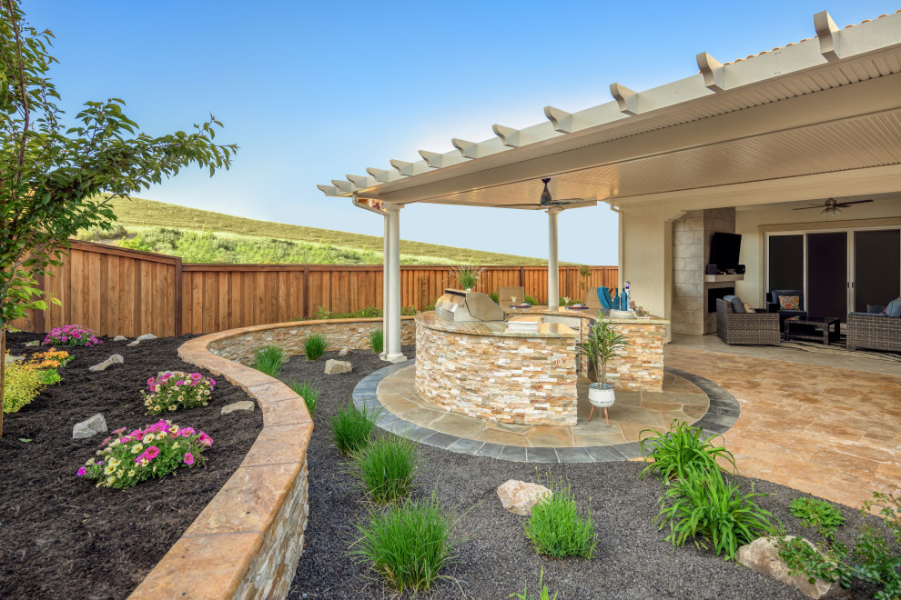 Idées déco pour une grande terrasse arrière éclectique avec une cuisine d'été, des pavés en pierre naturelle et une extension de toiture.
