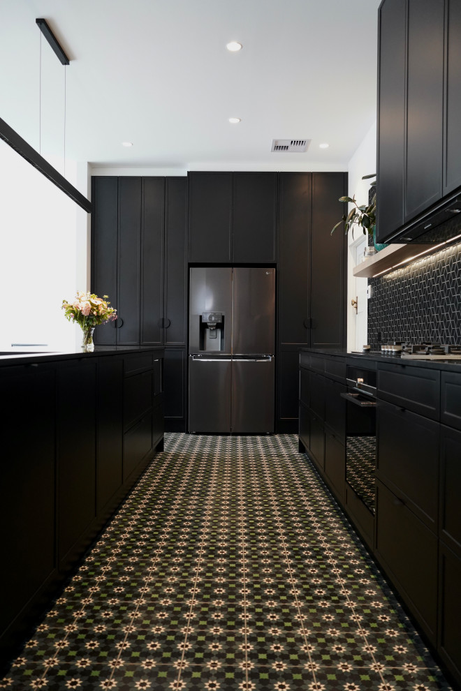 Foto på ett stort funkis svart kök, med en undermonterad diskho, skåp i shakerstil, svarta skåp, bänkskiva i kvarts, svart stänkskydd, stänkskydd i mosaik, svarta vitvaror, klinkergolv i keramik, en köksö och grönt golv